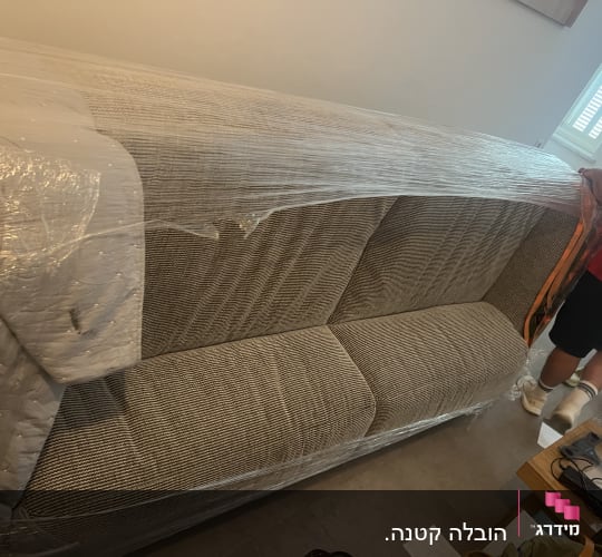 ספה עטופה בניילון עם אנשים מסביבה